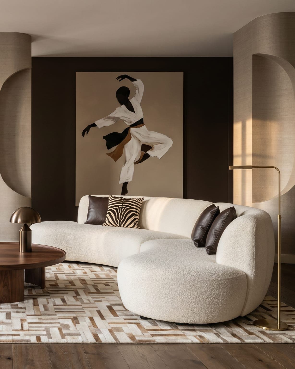 Curved cream bouclé sofa below a dancer artwork with a brass floor lamp and warm raking light — LKYOOB studio interior